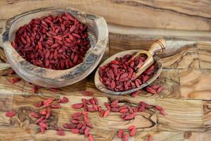 bagas de goji secas em madeira de oliveira foto