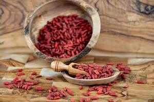 bagas de goji secas em madeira de oliveira foto