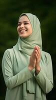 ai gerado retrato do uma bonita muçulmano mulher vestindo verde cachecol Rezar e sorridente ar livre. religioso, Paz e felicidade conceito foto