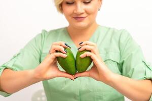 fêmea nutricionista médico segurando orgânico abacate fruta. saudável estilo de vida conceito. foto
