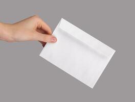 mão segurando branco envelope, correspondência, papel carta isolado foto