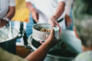 dando Comida para mendigos para Socorro reduzir fome com preocupação. conceitos do Comida doações e ajuda foto