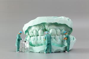 miniatura pessoas ,a dentista exibindo dental modelos e gesso ortodôntico modelos foto