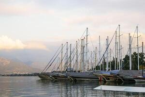 Fethiye, Peru - dezembro 8, 2022. luxuoso iates ancorado dentro uma tranquilo mar Porto às pôr do sol em uma fundo do montanhas. foto