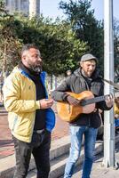 Istambul, Peru - dezembro 29, 2022. rua músico jogando guitarra para turistas em uma calçada portuguesa rua. foto