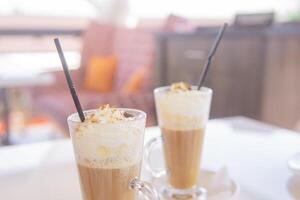 café é servido dentro uma alta vidro vidro com uma canudo. a conceito do café bebidas a partir de a Barra cardápio foto