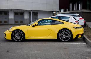 Minsk, bielorrússia, abril 17, 2024 - Porsche 911 carrera 4s estacionamento dentro rua foto