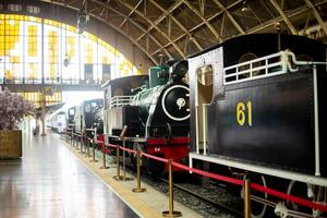 velho locomotiva dentro a depósito trem estrada de ferro estação museu com Sol luz passar através foto