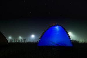 azul barraca com luz dentro noite e enevoado. foto