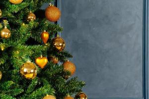 linda bugiganga dourada pendurada em uma árvore de natal foto