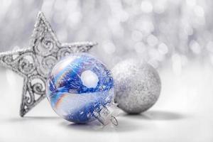 enfeites de Natal de prata e azul em fundo de bokeh de brilho com espaço para texto. natal e feliz ano novo foto