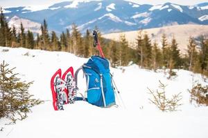 mochila, raquetes de neve e bastões de trekking. foto