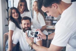 desfocar o retrato de jovens melhores amigos felizes com as mãos segurando o telefone em primeiro plano foto