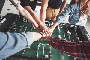 amigos juntos jogam jogos de tabuleiro, futebol de mesa e se divertem no tempo livre. foto