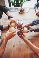 vista de cima. mãos de pessoas com copos de uísque ou vinho, celebrando e brindando em homenagem ao casamento ou outra celebração foto