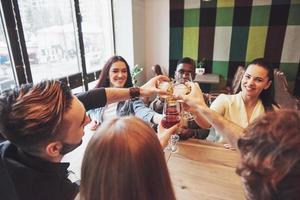 mãos de pessoas com copos de uísque ou vinho, celebrando e brindando em homenagem ao casamento ou outra celebração foto