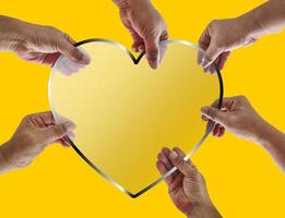 seis mãos segurando uma placa de vidro em forma de coração juntas. ilustração de compartilhar amor entre humanos