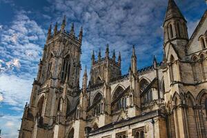 gótico catedral torre contra uma dramático nublado céu, exibindo intrincado arquitetônico detalhes e pináculos, ideal para histórico ou religioso temas dentro Iorque, norte yorkshire, Inglaterra. foto