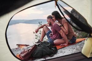 vista da tenda do casal deitado uma vista do lago durante a caminhada. conceito de estilo de vida avel aventura férias ao ar livre foto