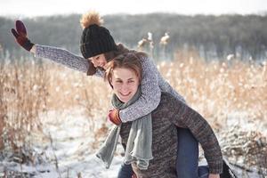 jovem casal feliz se diverte na neve fresca em um lindo dia ensolarado de inverno nas férias foto