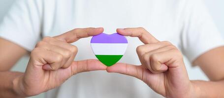 queer orgulho dia e lgbt orgulho mês conceito. roxo, branco e verde coração forma para lésbica, gay, bissexual, transgênero, genderqueer e pansexual comunidade foto