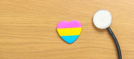 pansexual orgulho dia e lgbt orgulho mês conceito. rosa, amarelo e azul coração forma com estetoscópio para lésbica, gay, bissexual, transgênero, queer e pansexual comunidade foto