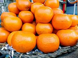 tangerina frutas em cesta para vender dentro Índia foto