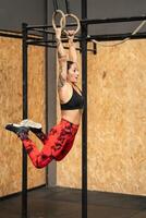 fêmea atleta Treinamento com olímpico argolas dentro uma Academia foto