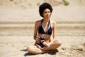 Preto fotógrafo dentro bikini em de praia foto