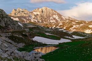 pôr do sol Visão do prutas montanha dentro durmitor nacional parque dentro Montenegro. neve permanece em a montanha. famoso caminhada destino. unesco mundo herança local. foto