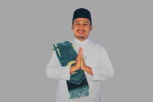 muçulmano ásia homem sorridente às a Câmera com mão Rezar pose foto