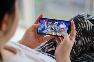 Pokémon ir Móvel ios jogos em Iphone 15 Smartphone tela dentro fêmea mãos durante Móvel jogabilidade foto