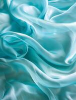 etéreo dobras e curvas do pálido aqua azul seda tecido crio uma macio, sonhadores composição destacando a delicado textura. foto