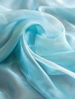 etéreo dobras e curvas do pálido aqua azul seda tecido crio uma macio, sonhadores composição destacando a delicado textura. foto