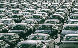 linhas do uma Novo carros estacionado dentro uma distribuição Centro em uma carro fábrica em uma ensolarado dia. topo Visão para a estacionamento. foto