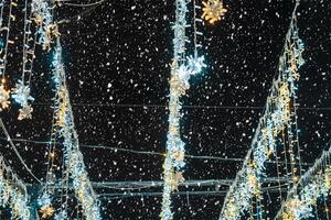 Natal guirlandas com conduziu lâmpadas com queda neve às noite. foto