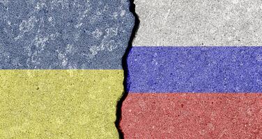 a rachadura entre a russo federação e ucraniano bandeiras em a concreto muro. a conceito do sanções, conflito e guerra. foto