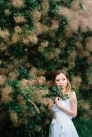 garota feliz em um vestido longo turquesa em um parque verde foto