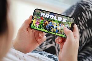 roblox Móvel ios jogos em Iphone 15 Smartphone tela dentro fêmea mãos durante Móvel jogabilidade foto