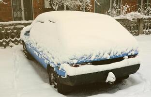 foto de um carro coberto por uma espessa camada de neve. consequências da forte nevasca