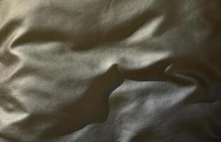 textura de couro preto ou dermantin com dobras, usado como material para bolsas femininas e masculinas, malas, almofadas para sofás de escritório e também para móveis estofados foto