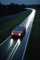 uma Esportes carro dirigindo baixa uma molhado estrada às noite foto