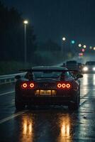 uma Esportes carro dirigindo baixa uma molhado estrada às noite foto