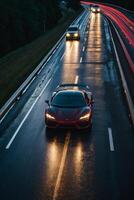 uma Esportes carro dirigindo em uma molhado estrada às noite foto