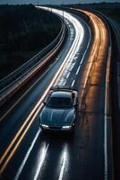 uma Esportes carro dirigindo em uma molhado estrada às noite foto