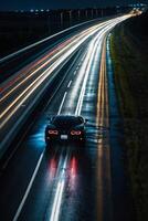 uma Esportes carro dirigindo em uma molhado estrada às noite foto