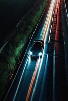 uma Esportes carro dirigindo em uma molhado estrada às noite foto