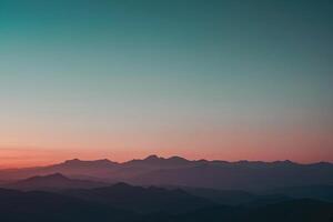 uma montanha alcance com uma pôr do sol dentro a fundo foto