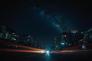 uma cidade rua às noite com luzes e estrelas foto