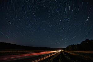 Estrela trilhas sobre uma rodovia às noite foto